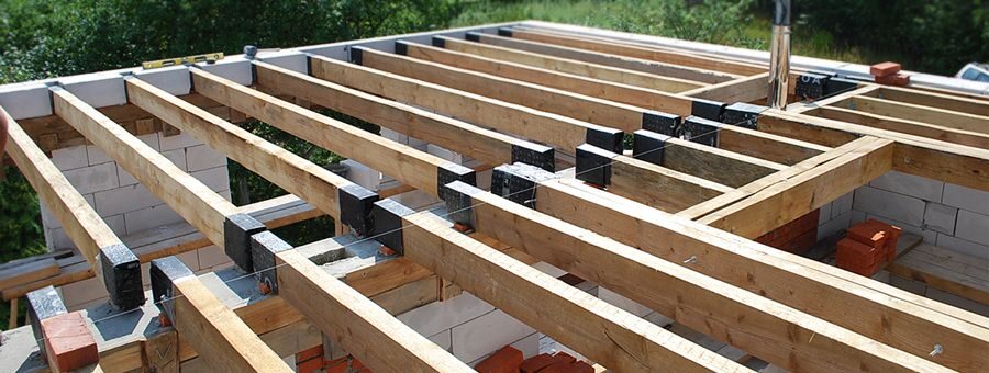 Работа по укладке деревянных балок на армопояс в газобетонном доме